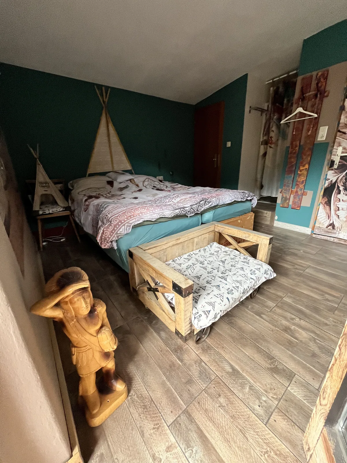 Slaapkamer met een groene muur en een tipimotief