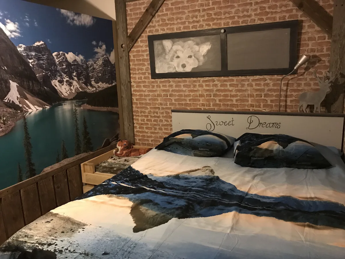 Slaapkamer met een bergenschilderij